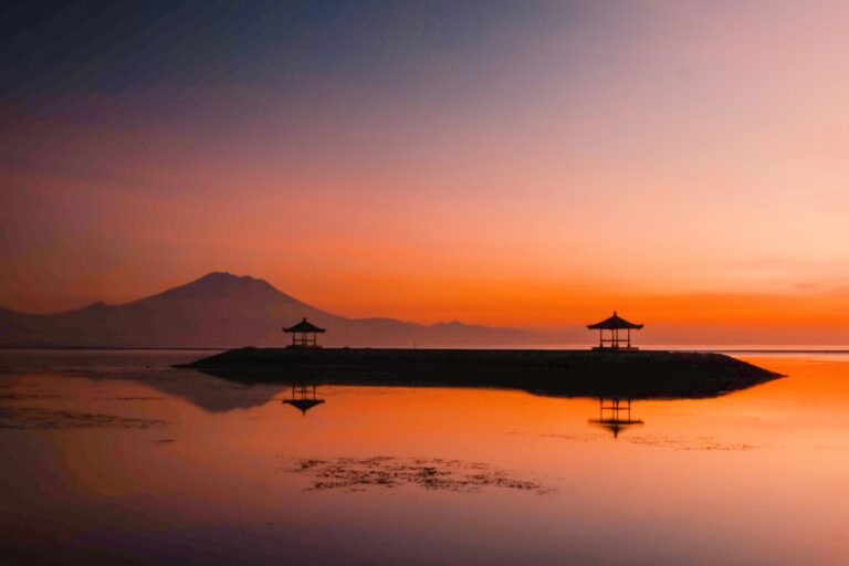 Bosan dengan kemacetan di area Bali Selatan? Bali masih menyimpan sisi tenang yang jauh dari hiruk-pikuk wisatawan massa. Jika Anda mencari ketenangan dan ingin menemukan sisi otentik Pulau Dewata, artikel ini akan memandu Anda menjelajahi lokasi-lokasi tersembunyi yang belum banyak diketahui orang. Destinasi Wisata Bali yang Masih Asri (H2) 1. Air Terjun Sekumpul, Buleleng (H3) Sering disebut sebagai air terjun tercantik di Bali. Terletak di utara, tempat ini menawarkan pemandangan tujuh air terjun dalam satu kawasan yang dikelilingi hutan rimbun. Cocok bagi Anda yang suka trekking dan petualangan. 2. Pantai Nyang Nyang, Uluwatu (H3) Berbeda dengan pantai populer lainnya, Nyang Nyang memerlukan sedikit usaha untuk dicapai. Namun, setelah menuruni anak tangga, Anda akan disambut garis pantai yang panjang, sepi, dan bangkai kapal karam yang artistik di atas pasir putih. 3. Desa Sidemen, Karangasem (H3) Jika Anda merindukan suasana Ubud 20 tahun lalu, Sidemen adalah jawabannya. Dengan latar belakang Gunung Agung yang megah dan hamparan sawah yang luas, tempat ini adalah lokasi terbaik untuk digital detox. Mengapa Memilih Jalur Wisata Alternatif? (H2) Menjelajahi sisi tersembunyi Bali tidak hanya soal foto yang bagus, tapi juga tentang: Koneksi dengan Budaya: Interaksi dengan penduduk lokal yang lebih hangat dan jujur. Biaya Lebih Terjangkau: Harga makanan dan akomodasi di area non-turis biasanya jauh lebih ramah di kantong. Ketenangan Mental: Menjauh dari kebisingan kota untuk benar-benar menikmati suara alam. Tips Mencari Lokasi Hidden Gem (H2) Gunakan Jasa Driver Lokal: Mereka biasanya tahu jalan pintas dan spot rahasia yang tidak muncul di Google Maps. Sewa Kendaraan yang Tangguh: Beberapa akses ke lokasi tersembunyi memiliki medan yang cukup menantang. Bawa Uang Tunai Secukupnya: Di area pedesaan, mesin ATM mungkin sulit ditemukan. Kesimpulan (H2) Bali lebih dari sekadar bar dan klub pantai. Dengan meluangkan waktu sedikit lebih jauh ke utara atau timur, Anda akan menemukan keajaiban alam yang masih murni dan menenangkan jiwa.